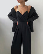 Ein modell in einem schwarz sexy riemen-overall und blazer