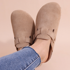 Nahaufnahme von beige orthopädische sandalen vor einem schlichten pastell-hintergrund